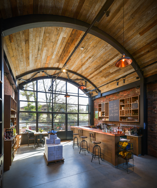 Inside Sedlescombe Organic Vineyard tasting room showing the arched ceiling and window and bar area