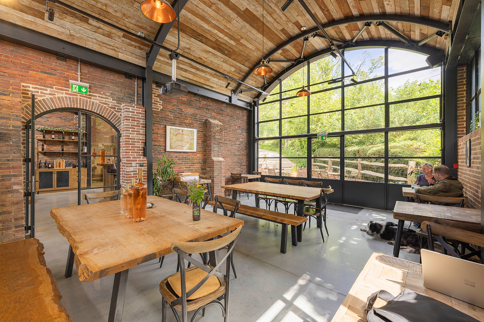 Inside Sedlescombe Organic Vineyard tasting room showing the arched ceiling and window and seating area
